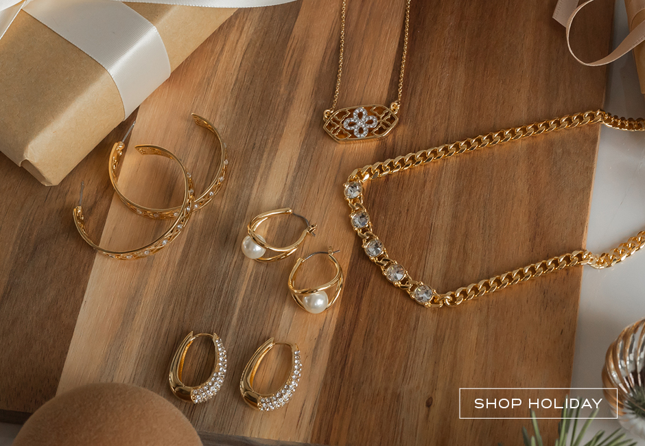 Flatlay of golden jewelry with pearls and crystal