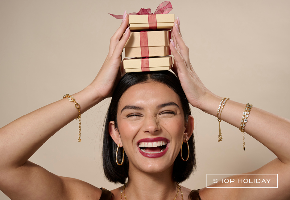 Woman holding holiday jewelry gifts wearing golden jewelry