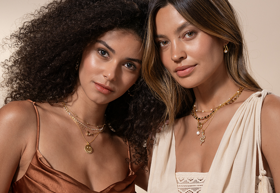 Women wearing gold layered necklaces snake, love, smile, pearl