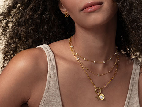 Woman wearing layered necklaces and charm necklace